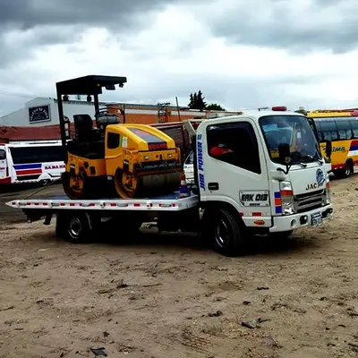 Grúa de plataforma transportando camioneta en Bogotá