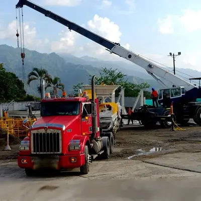 Grúa tipo pluma cargando container industrial